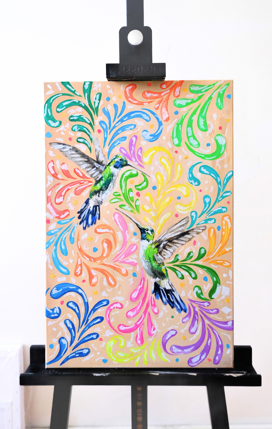 Acrylic painting of two hummingbirds among colourful swirls